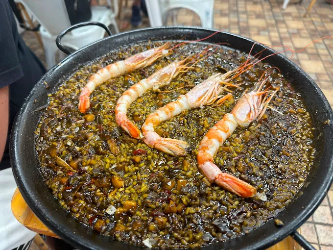 Arroz negro con gambones servido en paella